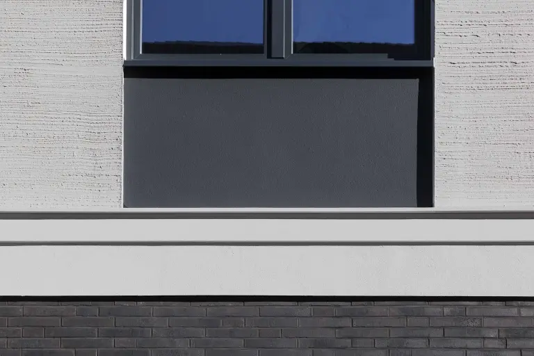 Oblikovanje fasade z ometom, fasadno barvo, klinkerjem in plastičnimi fasadnimi elementi na kontaktnem fasadnem sistemu. 